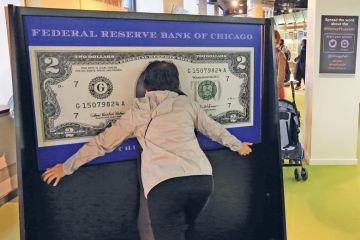 A visitor have photo taken within a 100 dollar bill in Money Museum in Federal Reserve Bank of Chicago. Illinois.USA