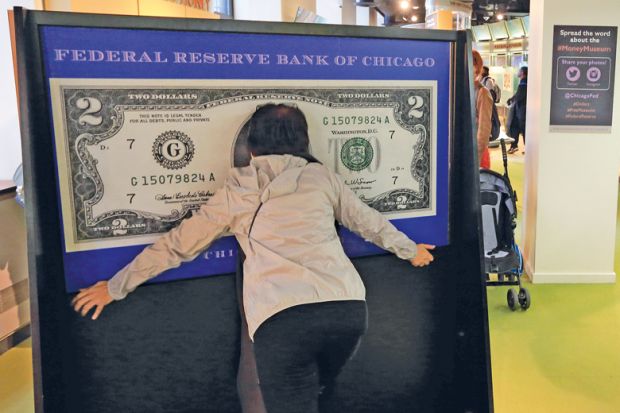 A visitor have photo taken within a 100 dollar bill in Money Museum in Federal Reserve Bank of Chicago. Illinois.USA