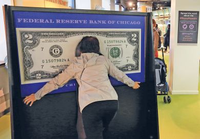 A visitor have photo taken within a 100 dollar bill in Money Museum in Federal Reserve Bank of Chicago. Illinois.USA